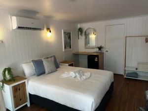 a bedroom with a bed with a towel on it at Central Motel Mooloolaba in Mooloolaba