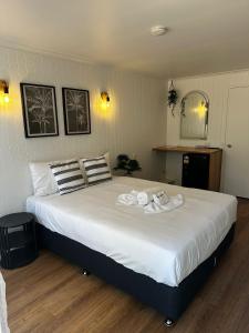 een slaapkamer met een groot bed met handdoeken erop bij Central Motel Mooloolaba in Mooloolaba