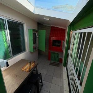 ein kleines Zimmer mit einem Tisch und einer Küche in der Unterkunft Casa Ver-de-perto o Mar in Barra Velha