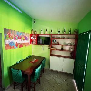 eine Küche mit grünen Wänden und einem Tisch und Stühlen in der Unterkunft Casa Ver-de-perto o Mar in Barra Velha + 5 Fotos