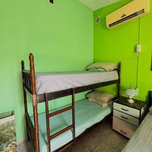 1 Schlafzimmer mit 2 Etagenbetten in einer grünen Wand in der Unterkunft Casa Ver-de-perto o Mar in Barra Velha