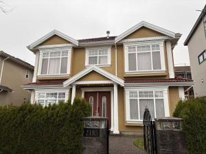 a yellow house with a gate in front of it at Vacation Home in Vancouver