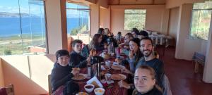 een groep mensen die aan een tafel in een restaurant zitten bij SUMAQ WASI LLACHON casa de Juana in Llachon