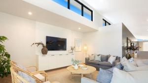 a living room with a couch and a table at Luxury On The Bay - Wanda in Suffolk Park