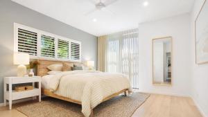 a white bedroom with a large bed and windows at Luxury On The Bay - Wanda in Suffolk Park +27 photos
