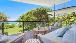 a bedroom on a deck with a bed and a table at Luxury On The Bay - Wanda in Suffolk Park