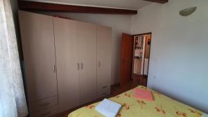 een slaapkamer met een bed en een grote witte kast bij Apartment Cunski 7951a in Čunski