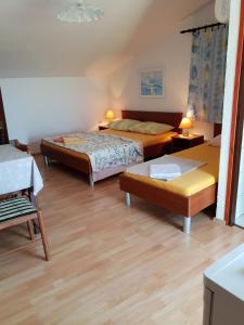 una camera d'albergo con due letti e un tavolo di Studio Cunski 7951a a Čunski