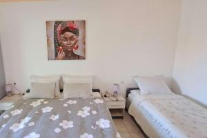 una camera da letto con due letti e un dipinto sul muro di Apartment Podaca 11274a a Viškovića Vala