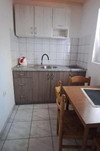 una cucina con un lavello e un tavolo con sedie di Apartment Podaca 11274a a Viškovića Vala Altre 9 foto