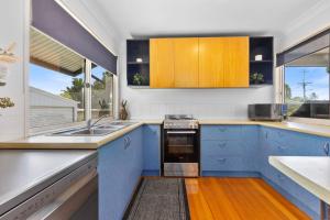 a kitchen with blue cabinets and a sink at Rainbow Tides - Rainbow Beach in Rainbow Beach