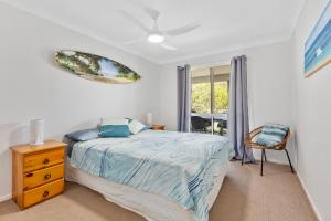 a bedroom with a bed and a dresser and a window at Rainbow Tides - Rainbow Beach in Rainbow Beach