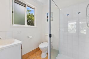 a bathroom with a toilet and a glass shower at Rainbow Tides - Rainbow Beach in Rainbow Beach