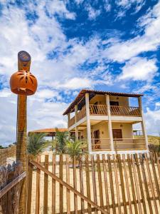 une maison derrière une clôture en bois avec une clôture gmaxwell gmaxwell gmaxwell dans l'établissement Chalé Sol de Macapá 2 - Refúgio Pertinho do Mar, à Luis Correia