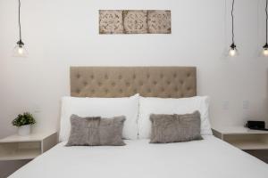 a bedroom with a large white bed with two pillows at Newington Apartments in Ballarat