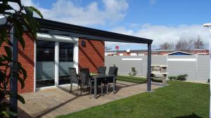 un patio con tavolo e sedie su un ponte di Ferienhaus Plattfisch a Dornum