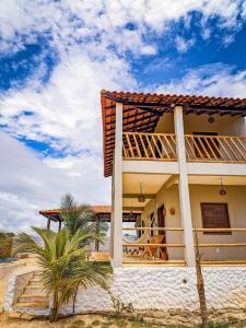 une maison avec un balcon sur la plage dans l'établissement Chalé Sol de Macapá 2 - Refúgio Pertinho do Mar, à Luis Correia