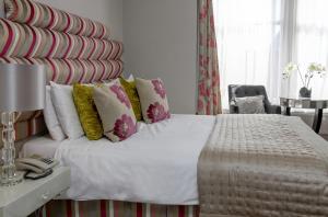a bedroom with a large white bed with colorful pillows at Best Western Brook Hotel in Felixstowe