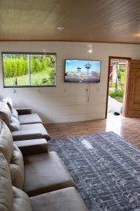 een woonkamer met banken en een flatscreen-tv bij Casa Alemã Alfredo Wagner SC in Alfredo Wagner
