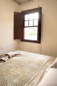 een slaapkamer met een bed en een raam bij Casa Alemã Alfredo Wagner SC in Alfredo Wagner