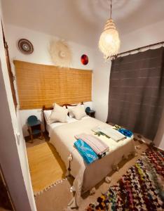 ein Schlafzimmer mit einem Bett und einem Kronleuchter in der Unterkunft Momo Surf Housse in Wassane