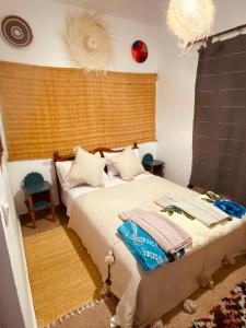 ein Schlafzimmer mit einem Bett und einem Kronleuchter in der Unterkunft Momo Surf Housse in Wassane