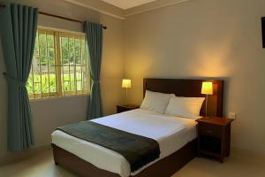 a bedroom with a large bed and a window at La Villa 23 Signature in Siem Reap