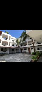 een groot wit gebouw met een palmboom ervoor bij Costa Ayala - Bungalow 6 with 2dbl beds, 2 sofas in Los Ayala