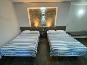 twee bedden in een kamer met een schilderij aan de muur bij Costa Ayala - Bungalow 6 with 2dbl beds, 2 sofas in Los Ayala