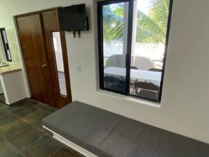 een woonkamer met een spiegel, een tafel en een raam bij Costa Ayala - Bungalow 6 with 2dbl beds, 2 sofas in Los Ayala