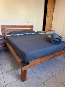 un letto in legno con lenzuola e cuscini blu sopra di Wine Hotel Punta Arena a Bahía de los Ángeles