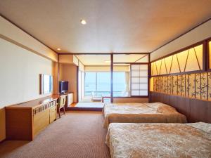 a hotel room with two beds and a television at Mikazuki Sea-Park Hotel Katsuura in Katsuura +56 photos