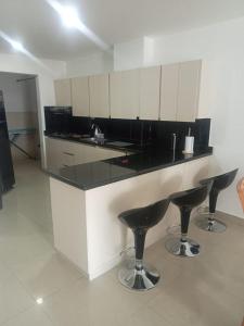 a kitchen with a counter with two bar stools at Comodo y amplio apartamento cerca a los mejores lugares de Cucuta in Cúcuta