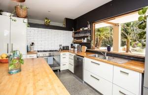 a kitchen with white cabinets and a large window at Honeybird Hideaway in Crabbes Creek