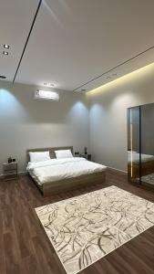 una camera con un letto e un grande tappeto di بيتك الثاني a Abha