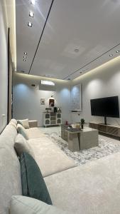 un soggiorno con divano e TV a schermo piatto di بيتك الثاني a Abha