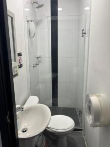 a bathroom with a toilet and a sink and a shower at Hotel Madeira in Manizales +21 photos