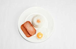 a plate of food with an egg and sausage at Guest hotel Palestina Pili in Pili