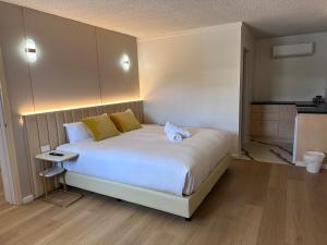 a bedroom with a large white bed with yellow pillows at Venus Resort in The Entrance