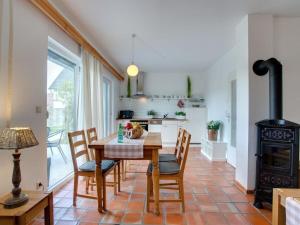 eine Küche mit Tisch und Stühlen und einem Herd in der Unterkunft Spreewald holiday home - Esox in Steinkirchen