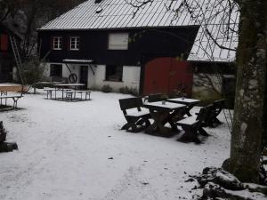 een picknicktafel in de sneeuw voor een huis bij Main building Neumühle in Lutzerath