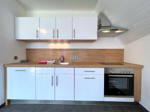 eine Küche mit weißen Schränken und einer Spüle in der Unterkunft Dream holiday apartment Kinzigblick in Schenkenzell