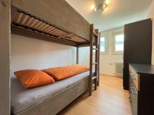 ein Etagenbett mit zwei orangefarbenen Kissen in einem Zimmer in der Unterkunft Dream holiday apartment Kinzigblick in Schenkenzell