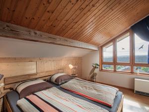 un letto in una stanza con soffitto in legno di Dream holiday apartment Stefan a Geroldsweiler
