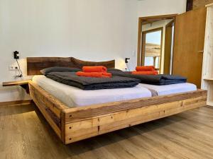een slaapkamer met een houten bed met oranje kussens erop bij Dream holiday apartment Kinzig-Chalet in Schenkenzell +12 foto's