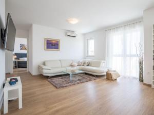 a white living room with a couch and a table at Villa in Bol with swimming pool in Bol