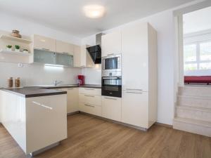 a kitchen with white cabinets and black appliances at Villa in Bol with swimming pool in Bol