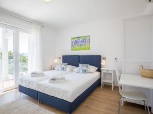 a white and blue bedroom with a bed and a desk at Villa in Bol with swimming pool in Bol +19 photos