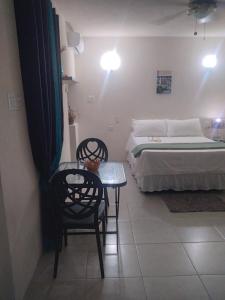a bedroom with a bed and a table and chairs at C'VAR Residential Vacation Apartment Rentals in Saint Michael