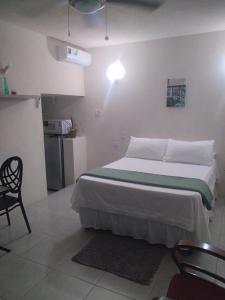 ein Schlafzimmer mit einem Bett und einem Stuhl sowie eine Küche in der Unterkunft C'VAR Community Vacation Apartment Rentals in Saint Michael